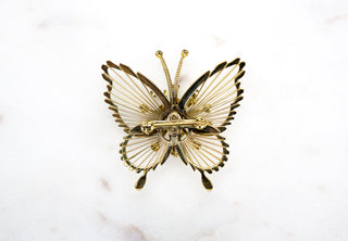 Filigree Butterfly Brooch Pin. Designer: Monet Period: 1960s Dimensions: 1.75”x2” Condition: Very good  An exceptional rendering of a butterfly by Monet with very delicate filigree framing centered with a dimensional burst of rhinestones. Available at Fonfrege.com