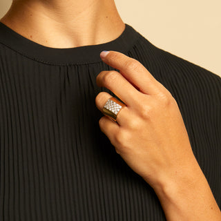 This elegant but understated ring features a square pavé of 23 round brilliant cut diamonds that sits like a buckle atop an 18K gold band. The band is countoured and narrows at the bottom. Approximately 0.65 carats total. 7.40 dwts. Available at fonfrege.com